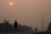 Joggers trot along the Reflecting Pool with the sun rising over the Washington Memorial and a thick layer of smoke, Thursday, June 8, 2023, in Washington. Intense Canadian wildfires are blanketing the northeastern U.S. in a dystopian haze, turning the air acrid, the sky yellowish gray and prompting warnings for vulnerable populations to stay inside. (AP Photo/Julio Cortez)